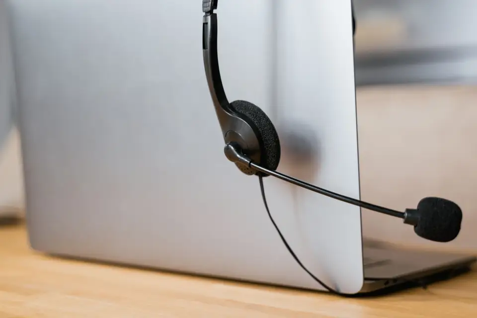 Auricular de atención al cliente junto a una computadora.