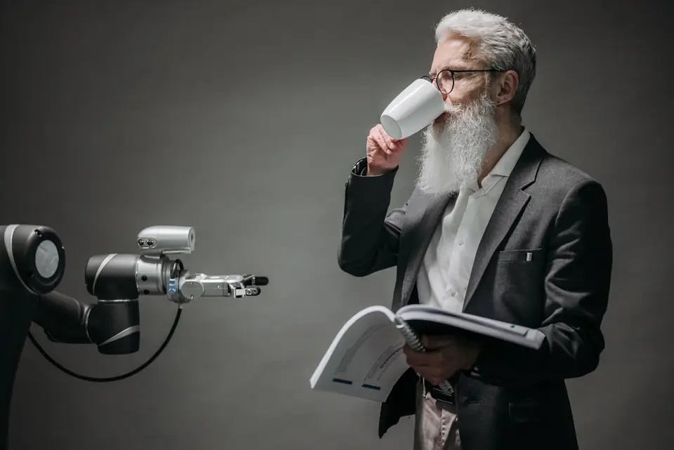 Una persona junto a un brazo robótico que sostiene una taza.